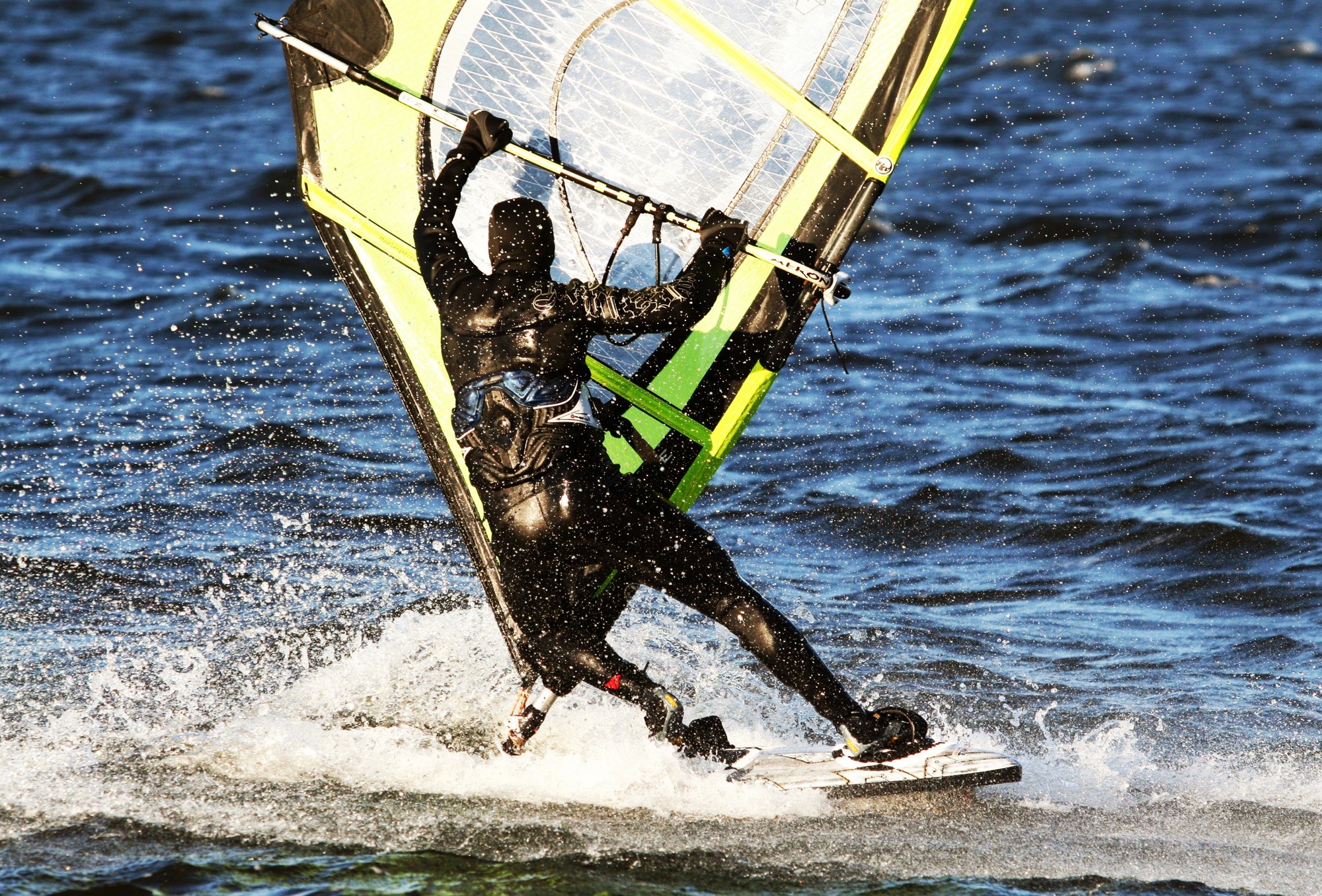 Closeup of a person in a swimming suit, windsurfing on a sunny day